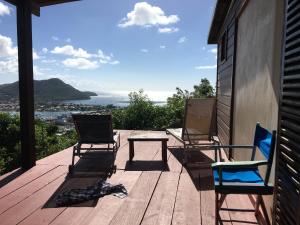 dwa krzesła i stół na drewnianym tarasie w obiekcie NEW- Rodney Bay two bedrooms BEST VIEW 6 w mieście Gros Islet