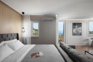 a bedroom with a bed and a couch and windows at Canova Apartment in Labin