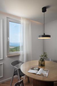 a table in a room with a window at Canova Apartment in Labin