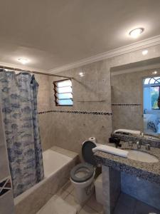 een badkamer met een bad, een toilet en een wastafel bij Hermoso Duplex Hotel BUGANVILLAS in Santa Cruz de la Sierra