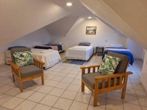 een slaapkamer op zolder met 2 bedden en 2 stoelen bij Hermoso Duplex Hotel BUGANVILLAS in Santa Cruz de la Sierra +17 foto's