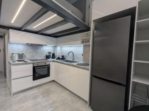 a kitchen with white cabinets and a stainless steel refrigerator at Mary's Loft in Tripoli +32 photos