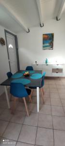 a table and chairs in a room with a kitchen at Ti kaz a fredo in Port-Louis +8 photos