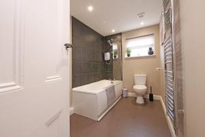 Un baño con bañera, inodoro y ventana. en Ashville Grange Sleeps 10 Large Beautiful House, en Scarborough 38 fotos más