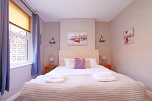 Un dormitorio con una cama grande con toallas. en Ashville Grange Sleeps 10 Large Beautiful House, en Scarborough