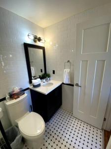 a bathroom with a toilet and a sink and a mirror at Cozy downtown studio getaway in Kingston
