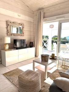 a living room with a television and a table at Jolie Maison Cosy Vue Golfe de Saint Tropez in Gassin