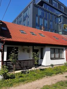a house with an orange roof in front of a building at Casa curte interioara, centru in Cluj-Napoca