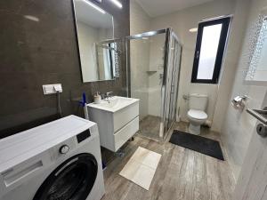 a bathroom with a washing machine and a toilet at The View Apartment 3 Bușteni in Buşteni +25 photos