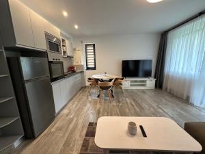 eine Küche und ein Wohnzimmer mit einem Tisch in der Unterkunft The View Apartment 3 Bușteni in Buşteni + 11 Fotos