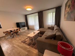 ein Wohnzimmer mit Sofa und Tisch in der Unterkunft The View Apartment 3 Bușteni in Buşteni