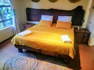 a bedroom with a large bed with yellow sheets and pillows at UrbanEscape in Centurion