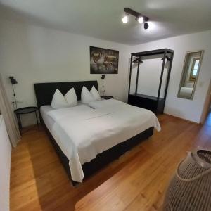 sypialnia z dużym łóżkiem z białą pościelą w obiekcie Living Apart Haslwanter Ferienwohnung w mieście Haiming