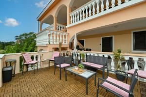 un patio con sedie e tavoli su un balcone di Villa Schubert a Novalja (Novaglia)