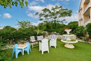 un cortile con sedie, un tavolo e una fontana di Villa Schubert a Novalja (Novaglia) Altre 83 foto