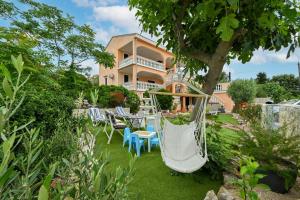 una casa con un cortile con sedie e un'amaca di Villa Schubert a Novalja (Novaglia)