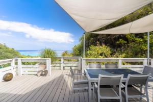 una terraza con una mesa y sillas azules y el océano en Maruapo lodge, en Punaauia