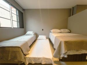 a room with two beds and a window at Apartamento Moderno Zona 7 LP13 in Maringá +2 photos