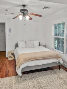 a bedroom with a bed with a ceiling fan at Simply Get-A-Waco- HOT TUB, Sleeps 10, 5-min Walk to Silos & Downtown Waco in Waco