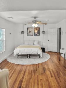 a white bedroom with a bed and a ceiling fan at Simply Get-A-Waco- HOT TUB, Sleeps 10, 5-min Walk to Silos & Downtown Waco in Waco +35 photos
