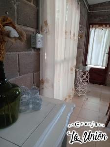 a room with a table with a vase and a window at Granja La Unión in Villa Dolores