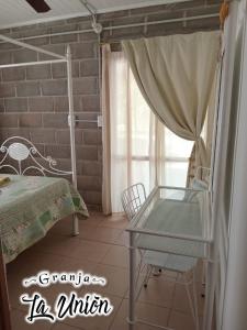 a bedroom with a bed and a table and a window at Granja La Unión in Villa Dolores +21 photos