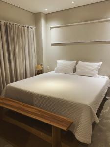 a bedroom with a large bed with white sheets at Beach House Brazil in Amontada