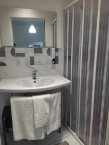a bathroom with a sink and a shower with towels at Kamurria House in Catania