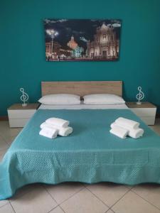 a blue bedroom with a bed with two white towels at Kamurria House in Catania +22 photos