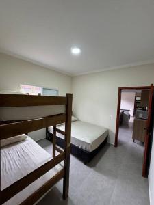 a bedroom with two bunk beds and a mirror at Casa na praia com piscina e Wi-fi in Mongaguá