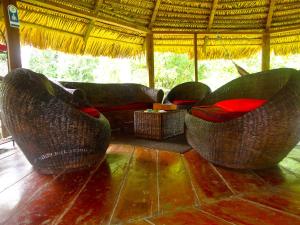 a living room with wicker chairs and a couch at Cuyabeno River Lodge in Marian