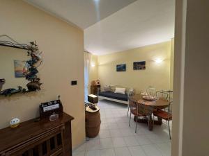 a living room with a table and a couch at 5 Terre Express Holiday House - Migliarina in Isola +5 photos