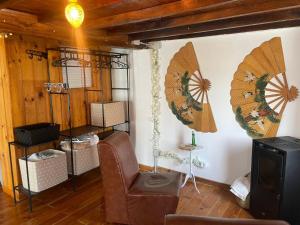 a living room with a chair and a wall with umbrellas at La Carmencita in Cedeira