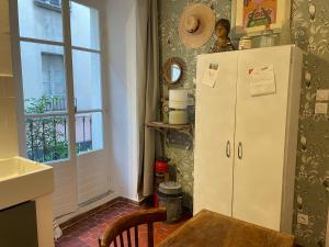 a kitchen with a refrigerator and a table and a window at Sainte Anne in Apt +30 photos