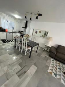 ein Wohnzimmer mit Tisch und Stühlen und eine Küche in der Unterkunft Estrelicia III in Marbella