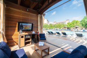 sala de estar con TV y sillas y piscina en JW Marriott San Antonio Hill Country Resort & Spa, en San Antonio