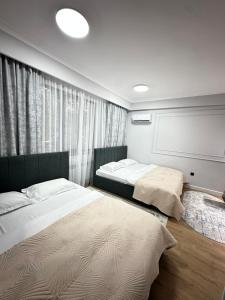 Un dormitorio con dos camas y una ventana en Апарт-отель AMZ, en Almaty