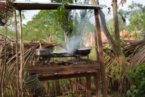 two pots and pans on a grill with smoke at Xingú Camping Site in Leticia