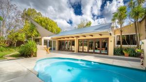 a swimming pool in front of a house at Botanica Guest House in George