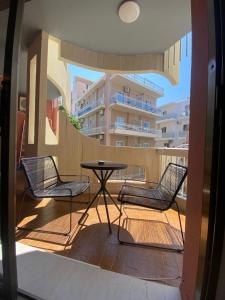 a patio with two chairs and a table on a balcony at Blue Cozy Nest in Rhodes Town