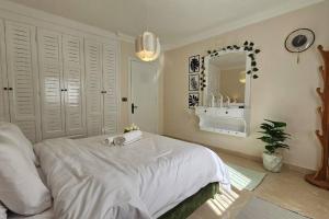 a bedroom with a white bed and a mirror at Heaven with wide view garden in Madinaty