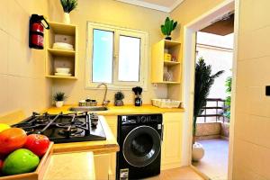 a kitchen with a stove and a washing machine at Heaven with wide view garden in Madinaty +15 photos