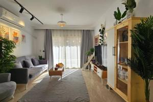 a living room with a couch and a tv at Heaven with wide view garden in Madinaty