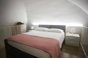 a bedroom with a large white bed and two night stands at Margaret Home- Casa Vacanze con Self Check In in Gravina in Puglia