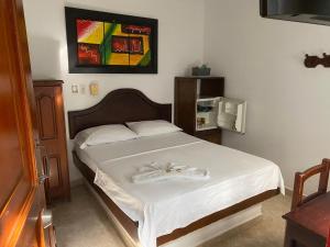 a bedroom with a bed with a white bedspread at Hotel Boyaca in Puerto Boyacá