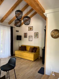 sala de estar con sofá amarillo y silla en M&M Apartments, en Kotor