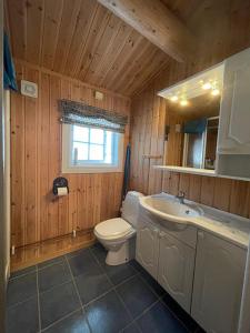 a wooden bathroom with a toilet and a sink at Mountain family cabin in Trysil