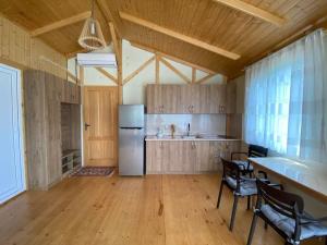 a kitchen with a refrigerator and a table and chairs at Kontsikho Cottage in Mukhli, Ambrolauri in Mukhli