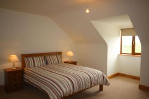 a bedroom with a bed and two lamps on tables at King's Lodge in Cleggan +28 photos