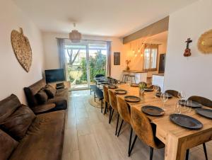 a dining room with a long table and a couch at Smoothie in Canet-en-Roussillon